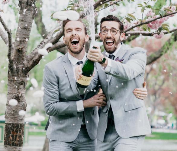 2 men celebrating with a bottle of wine