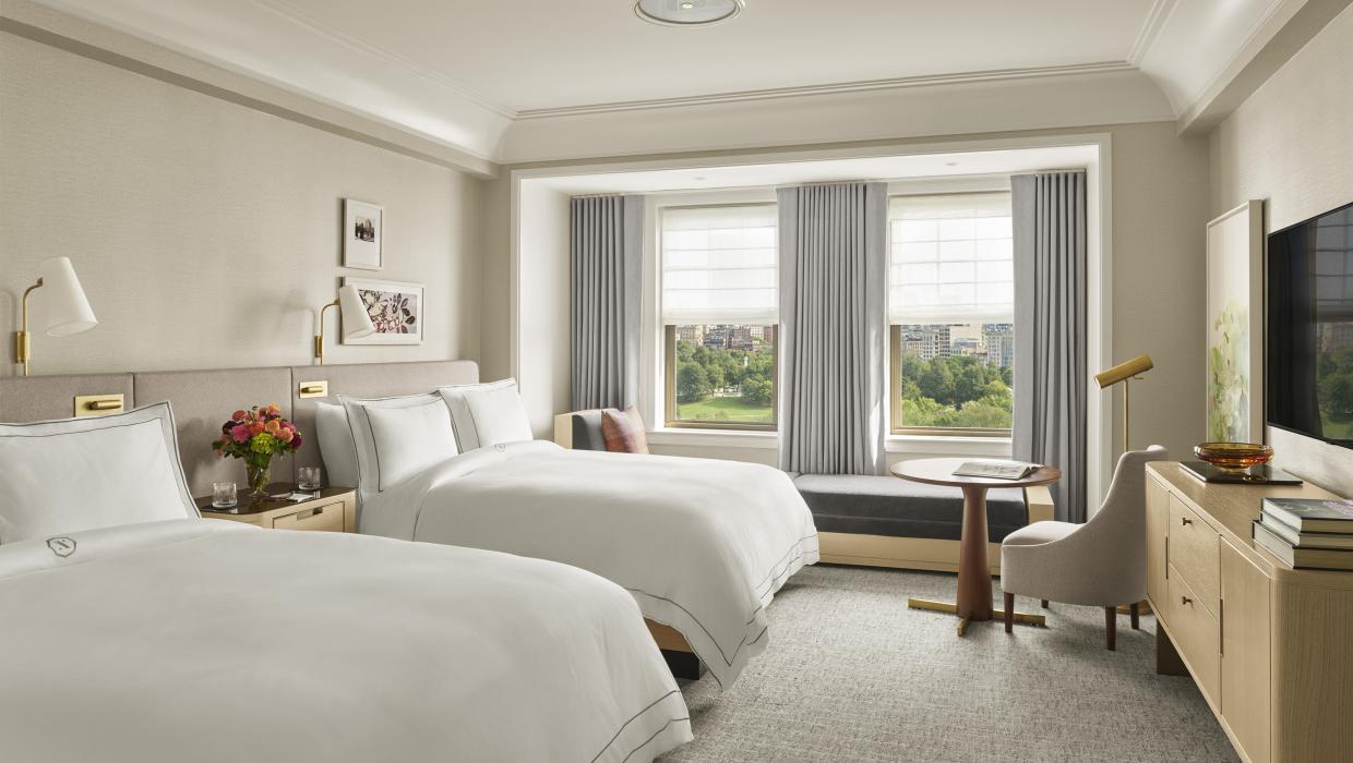 interior shot of bedroom with two queen beds and windows overlooking park