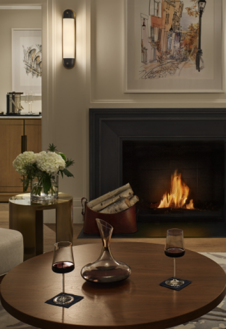 Newbury hotel room with fire burning in fireplace and wine on table 