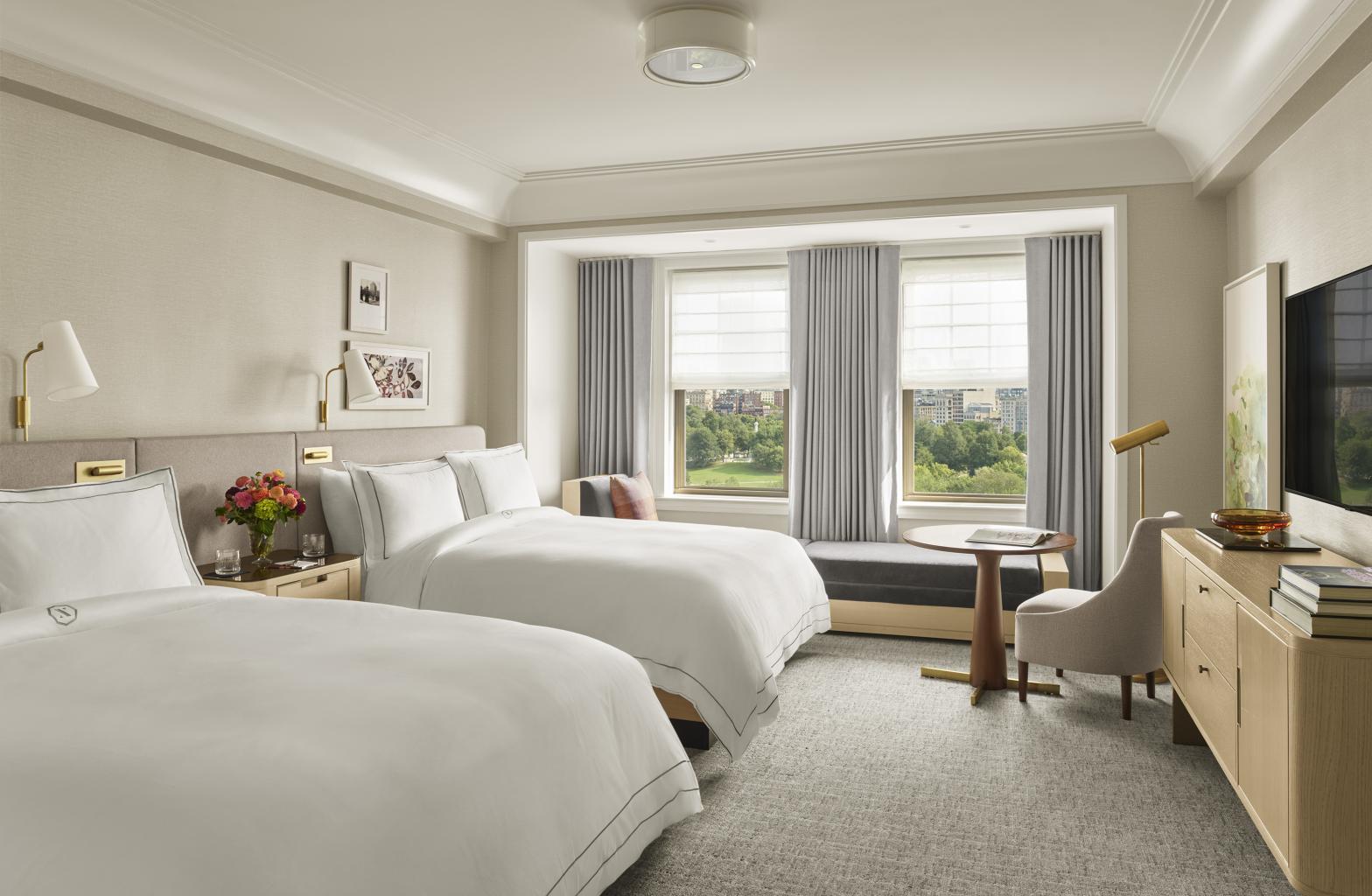interior shot of bedroom with two queen beds and windows overlooking park