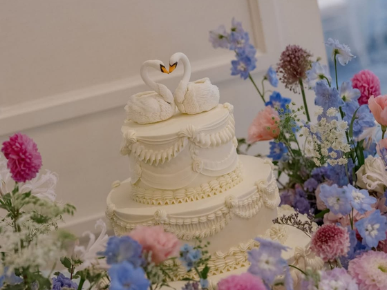 White wedding cake with swan toppers