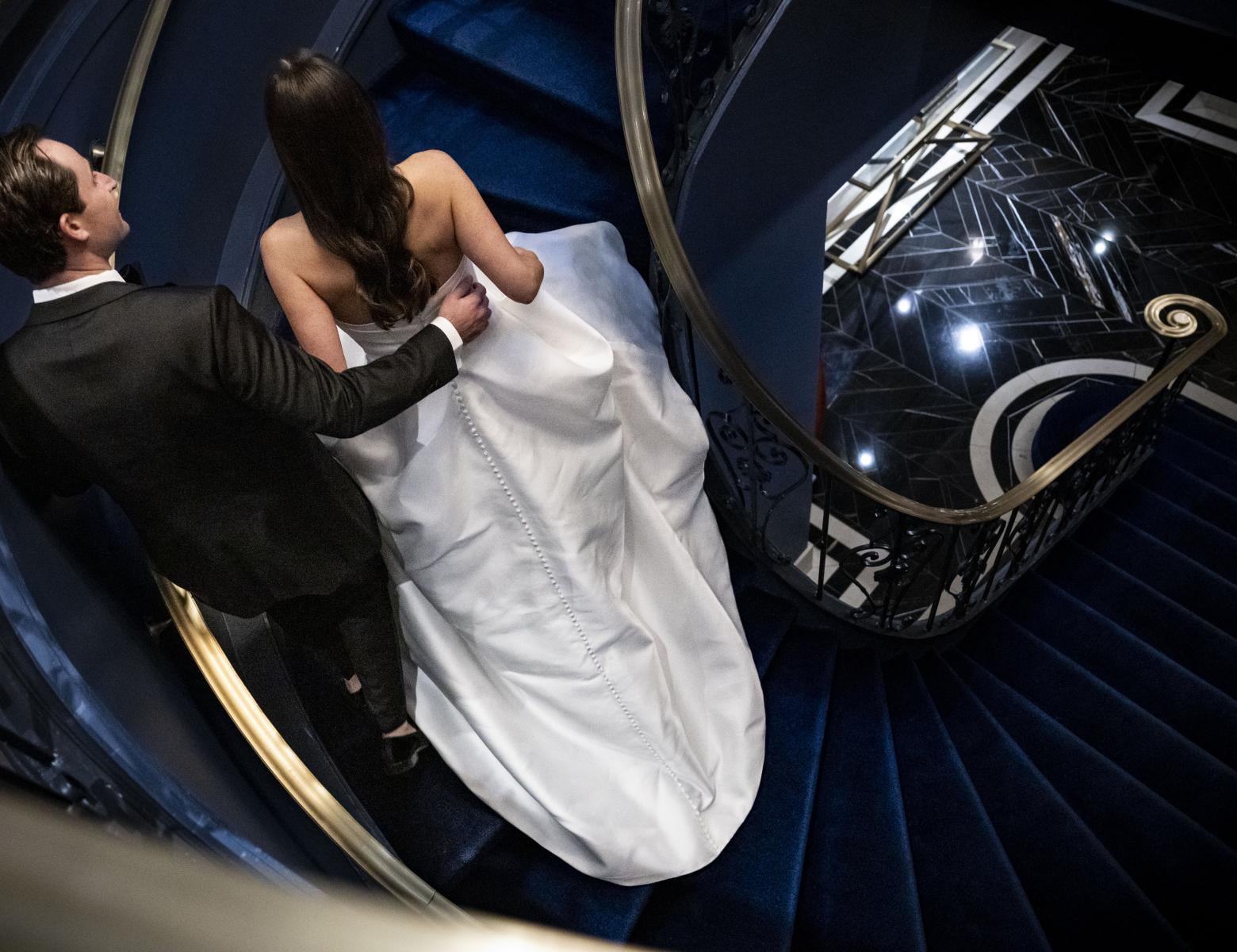 aerial shot from above of bride and groom going down stairs 